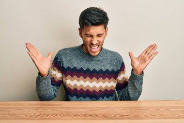 Genç, yakışıklı bir adam, gündelik kazağını giymiş, çılgın ve başarıyı kutluyor. Kolları havada, gözleri kapalı, heyecanlı bir şekilde bağırıyor. Kazanan konsept 