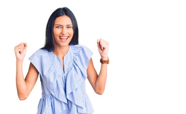 Genç, güzel, Latin bir kız, günlük kıyafetler giyiyor kızgın ve kızgın. Öfkeyle bağırırken yumruklarını kaldırıyor. öfke ve agresif konsept. 