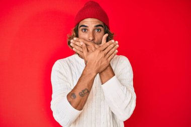 Yün kazak ve kış şapkası giyen İspanyol genç adam yanlışlıkla ağızlarını kapatarak şok geçirdi. gizli kavram. 