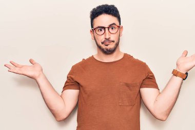 Gündelik kıyafetler giyen genç İspanyol adam habersiz ve kolları açık, hiçbir fikri ve şüpheli bir yüzü var.. 