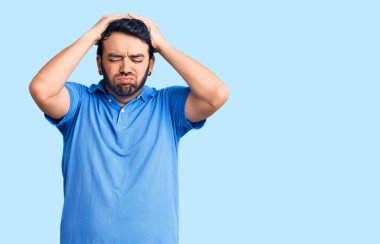 İspanyol asıllı genç adam gündelik giysiler giyiyor. Baş ağrısı çekiyor. Acı ve migren yüzünden çaresiz ve stresli. Eller başının üstünde.. 