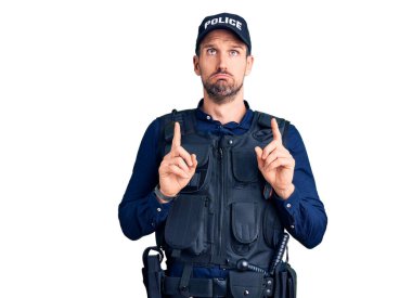 Polis üniforması giyen genç yakışıklı adam üzgün ve üzgün görünüyor, parmaklarıyla yön gösteriyor, mutsuz ve depresif.. 