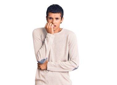 Genç Afrikalı Amerikalı sıradan kıyafetler giyen gergin ve gergin görünen elleri ağız yiyen tırnakları olan bir adam. anksiyete. 