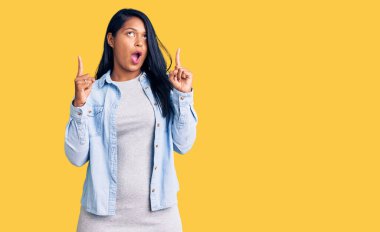 Uzun saçlı İspanyol kadın sıradan bir kot ceket giyiyordu. Şaşırmış ve şaşırmıştı. Parmaklarıyla işaret ediyor ve kollarını kaldırıyordu.. 