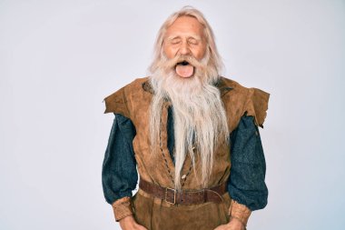 Gri saçlı, uzun sakallı, Viking kostümü giyen ve dilini komik bir ifadeyle dışarı çıkaran son sınıf öğrencisi. duygu kavramı. 