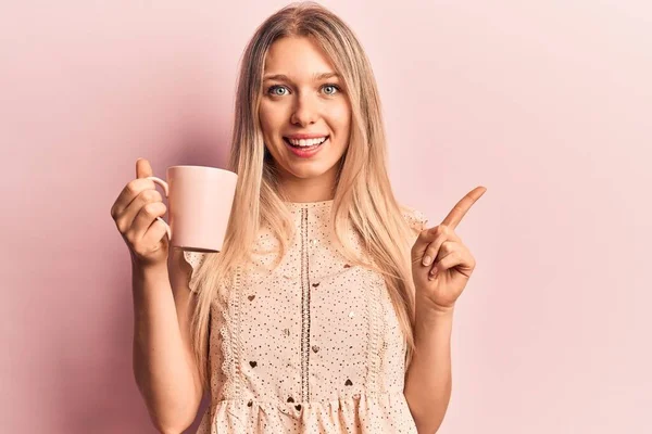 Jovem Bela Mulher Loira Segurando Café Sorrindo Feliz Apontando Com — Fotografia de Stock