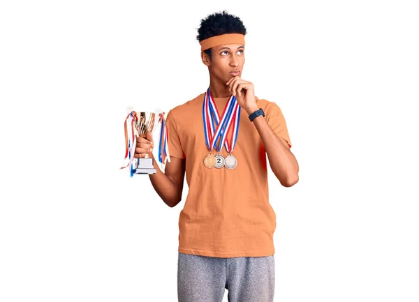 Jovem Afro Americano Segurando Troféu Campeão Vestindo Medalhas Rosto Sério — Fotografia de Stock