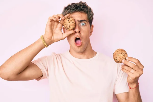 Jeune Homme Beau Tenant Cookie Effrayé Choqué Par Surprise Expression — Photo