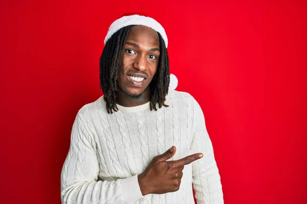 Africano Americano Com Tranças Vestindo Chapéu Natal Apontando Para Lado — Fotografia de Stock