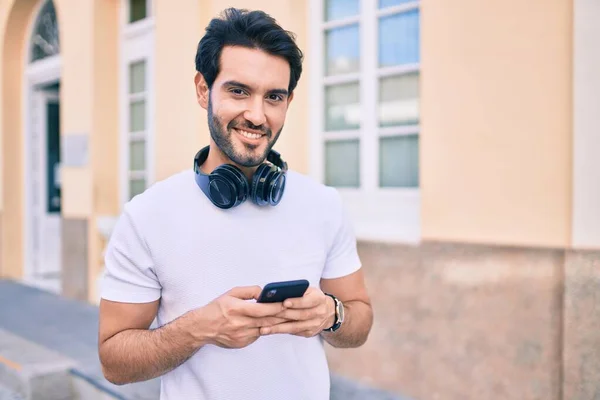 Joven Hombre Hispano Sonriendo Feliz Usando Teléfonos Inteligentes Auriculares Ciudad — Foto de Stock