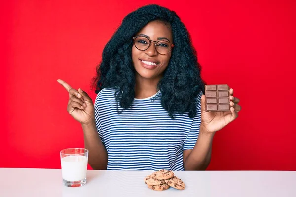 Mooie Afrikaanse Vrouw Die Een Chocoladereep Eet Een Glas Melk — Stockfoto