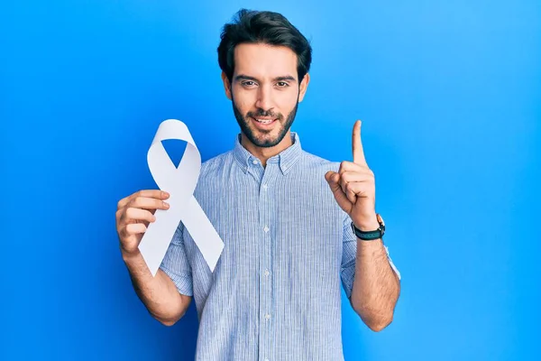 Joven Hispano Sosteniendo Cinta Azul Sonriendo Con Una Idea Pregunta — Foto de Stock