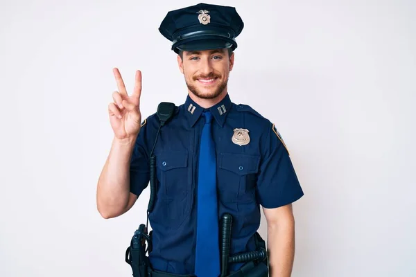 Ung Kaukasisk Man Klädd Polisuniform Leende Tittar Kameran Visar Fingrarna — Stockfoto