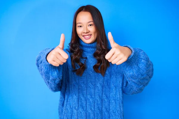스웨터를 아름다운 소녀는 손으로 긍정적 행동을 승자의 — 스톡 사진
