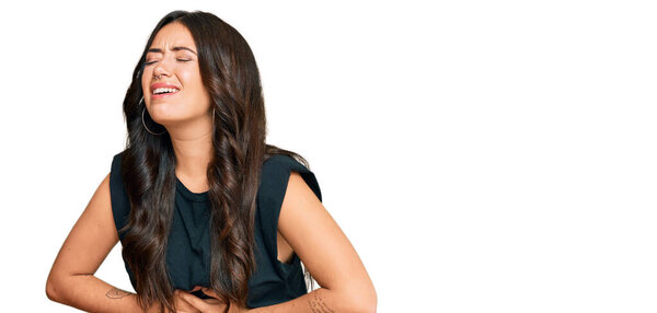 Красивая брюнетка молодая женщина в черной рубашке с рукой на животе, потому что тошнота, болезненное заболевание чувствует себя нездоровым. Концепция. 