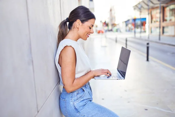 漂亮的年轻女人穿着时髦的衣服走在大街上 用电脑笔记本电脑工作 — 图库照片