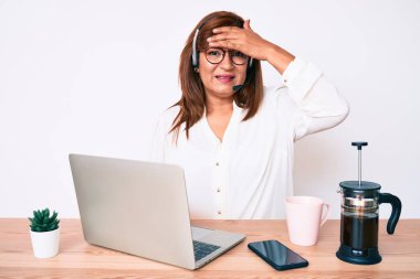 Orta yaşlı esmer, ofiste çalışan, operatör kulaklığı takan, kafası karışık, şaşırmış ve sinirli bir kadın. 