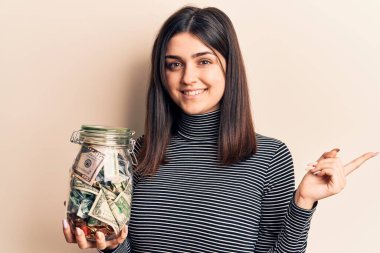 Bahşiş kavanozunu tutan genç ve güzel bir kız gülümsüyor. 