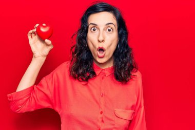 Genç ve güzel İspanyol bir kadın kalbi tutuyor. Korkmuş ve şaşkın bir şekilde ağzı açık, şaşırmış ve şaşırmış. 