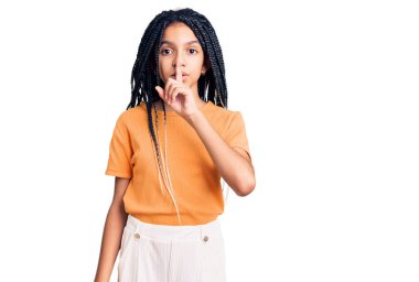 Hoş Afro-Amerikalı kız günlük kıyafetler giyip dudakları parmaklarla sessiz olmak istiyor. sessizlik ve gizli konsept. 