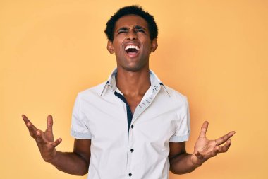 Sıradan gömlekler giyen Afrikalı yakışıklı adam deli gibi bağırıyor ve agresif bir ifade ve kollarla bağırıyor. hüsran kavramı. 