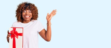 Genç Afrikalı Amerikalı kadın zaferi mutlu bir gülümseme ve kazanan bir ifadeyle kutluyor. 