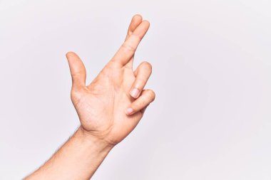 İzole edilmiş arka plan üzerinde genç beyaz adamın eli kapalı. Parmaklar çapraz, batıl inançlar ve şanslı jest, şanslı ve umut ifadesi. 