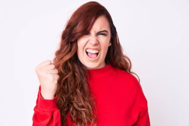 Genç, güzel bir kadın, kızgın ve kızgın. Öfkeyle bağırırken yumruğunu sallıyor ve öfkeleniyor. öfke ve agresif konsept. 