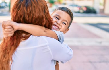 Sevimli Latin anne ve oğlu gülümsüyor. Mutlu bir şekilde şehre sarılıyorlar..
