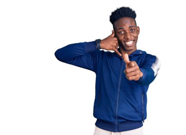 Afro-Amerikalı genç adam spor kıyafetleri giyiyor gülümsüyor telefonda konuşuyor ve seni işaret ediyor. Ara beni.. 