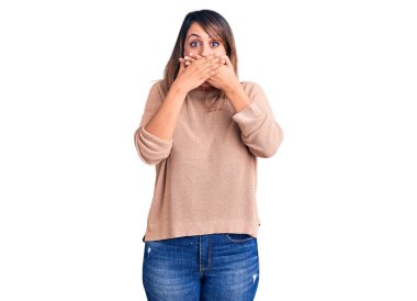 Gündelik kazak giyen genç ve güzel bir kadın yanlışlıkla elleriyle ağzını kapatırken şok oldu. gizli kavram. 