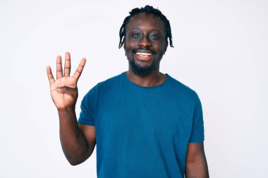 Saçları örgülü genç Afro-Amerikalı adam dört numarayı gösterip gösterirken kendinden emin ve mutlu gülümsüyor.. 