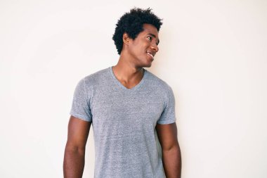 Afro saçlı, rahat görünmeye çalışan, doğal yüzüyle poz veren ve kendine güvenen Afro saçlı yakışıklı bir Amerikalı.. 