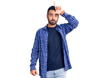 Latin asıllı genç adam sıradan kıyafetler giyiyor. Alnında parmakları olan insanlarla dalga geçiyor. Ezik hareketler yapıyor, alay ediyor, hakaret ediyor.. 