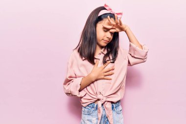 Güzel bir kız çocuğu günlük giysiler giyiyor. Hastalık ve ateş için alnına dokunuyor. Grip ve soğuk algınlığı. 