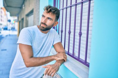 Şehrin duvarına yaslanmış, ciddi bir suratı olan genç bir İspanyol.