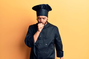 Pişirme üniforması giyen İspanyol genç adam kendini iyi hissetmiyor ve soğuk algınlığı veya bronşitin belirtisi olarak öksürüyor. sağlık hizmeti kavramı. 