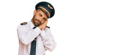Sakallı yakışıklı bir adam, uçak pilotu üniforması giyiyor. Yorgun uyuyor, hayal kuruyor, elleriyle poz veriyor, gözleri kapalı gülümsüyor.. 
