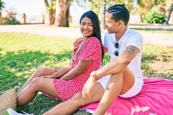 Genç Latin Çift Mutlu Gülümsüyor Parkta Çimlerin Üzerinde Oturuyor — Stok fotoğraf