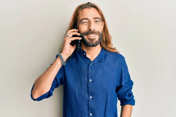 Aantrekkelijke Man Met Lang Haar Baard Praten Smartphone Kijken Positief — Stockfoto