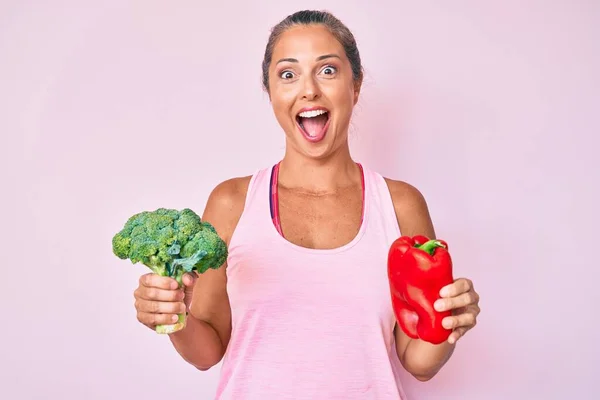 Mujer Hispana Mediana Edad Sosteniendo Brócoli Pimiento Rojo Celebrando Loco — Foto de Stock