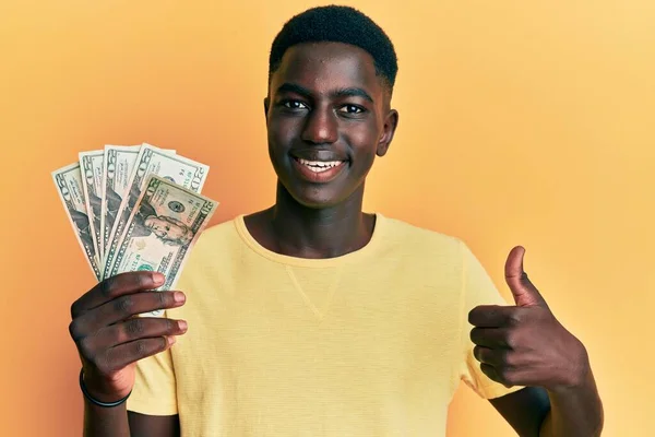 Fiatal Afro Amerikai Férfi Kezében Dollár Mosolyogva Boldog Pozitív Hüvelykujj — Stock Fotó