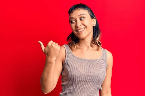 Jovem Mulher Vestindo Roupas Casuais Apontando Polegar Para Lado Sorrindo — Fotografia de Stock