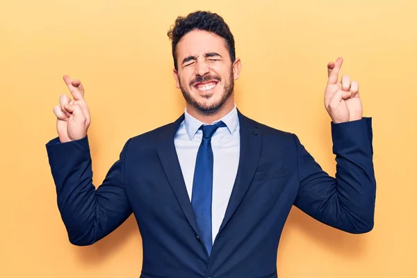 Young Hispanic Man Wearing Suit Gesturing Finger Crossed Smiling Hope — Stock Photo, Image