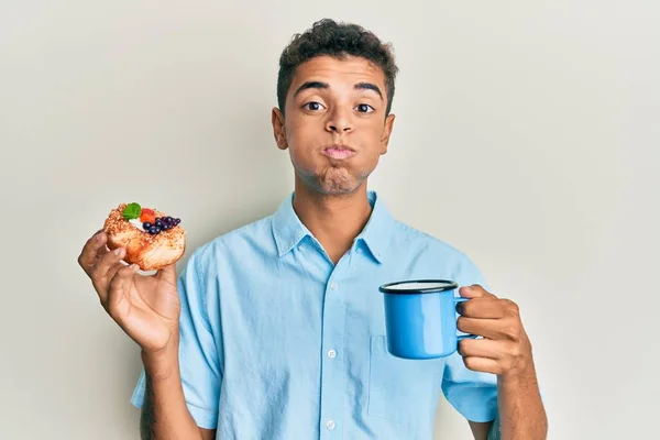 Young Handsome African American Man Drinking Coffee Eating Pastry Puffing — Stock Photo, Image