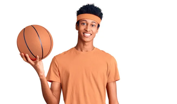 Joven Hombre Afroamericano Sosteniendo Pelota Baloncesto Mirando Positiva Feliz Pie — Foto de Stock