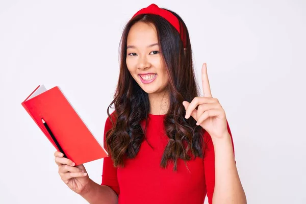 Jovem Menina Chinesa Bonita Segurando Livro Surpreso Com Uma Ideia — Fotografia de Stock