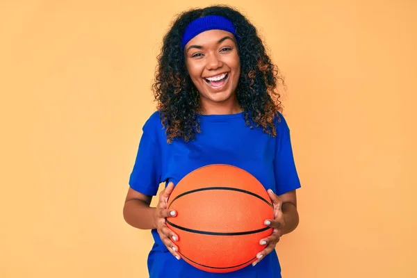 若いアフリカ系アメリカ人女性を保持バスケットボールボール笑顔と笑いハードアウト大声でなぜなら面白いクレイジー冗談 — ストック写真