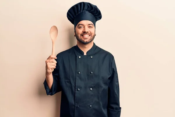 Joven Hombre Hispano Con Uniforme Cocina Sosteniendo Cuchara Con Aspecto — Foto de Stock
