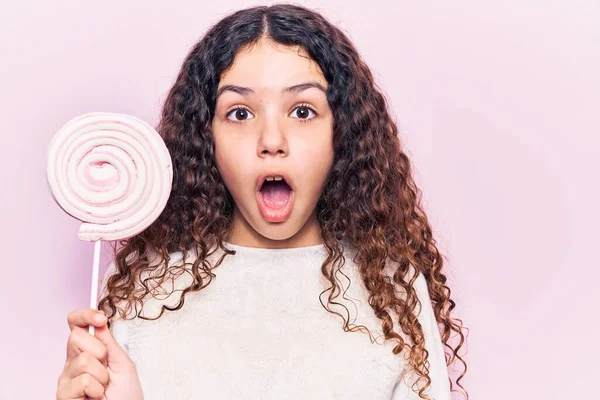 Kıvırcık Saçlı Lolipop Tutan Güzel Bir Kız Ağzı Açık Kalmış — Stok fotoğraf